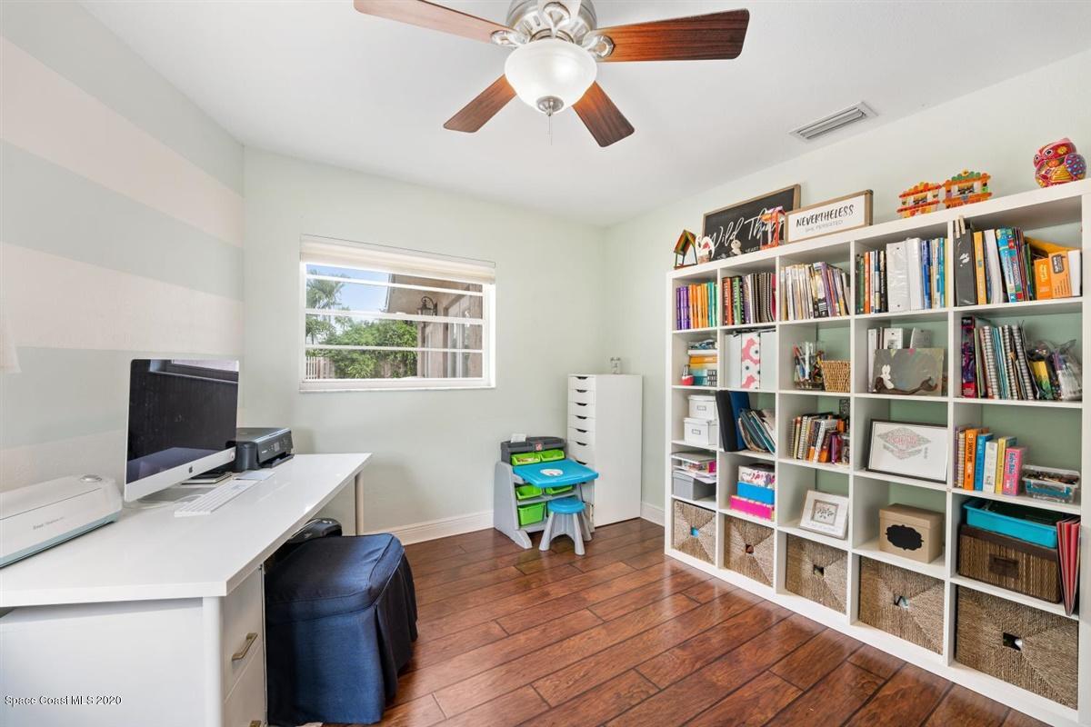 108 Neptune Court Indialantic, FL 32903 - Photo 28 of 33 a living room with bookshelf and a flat screen tv
