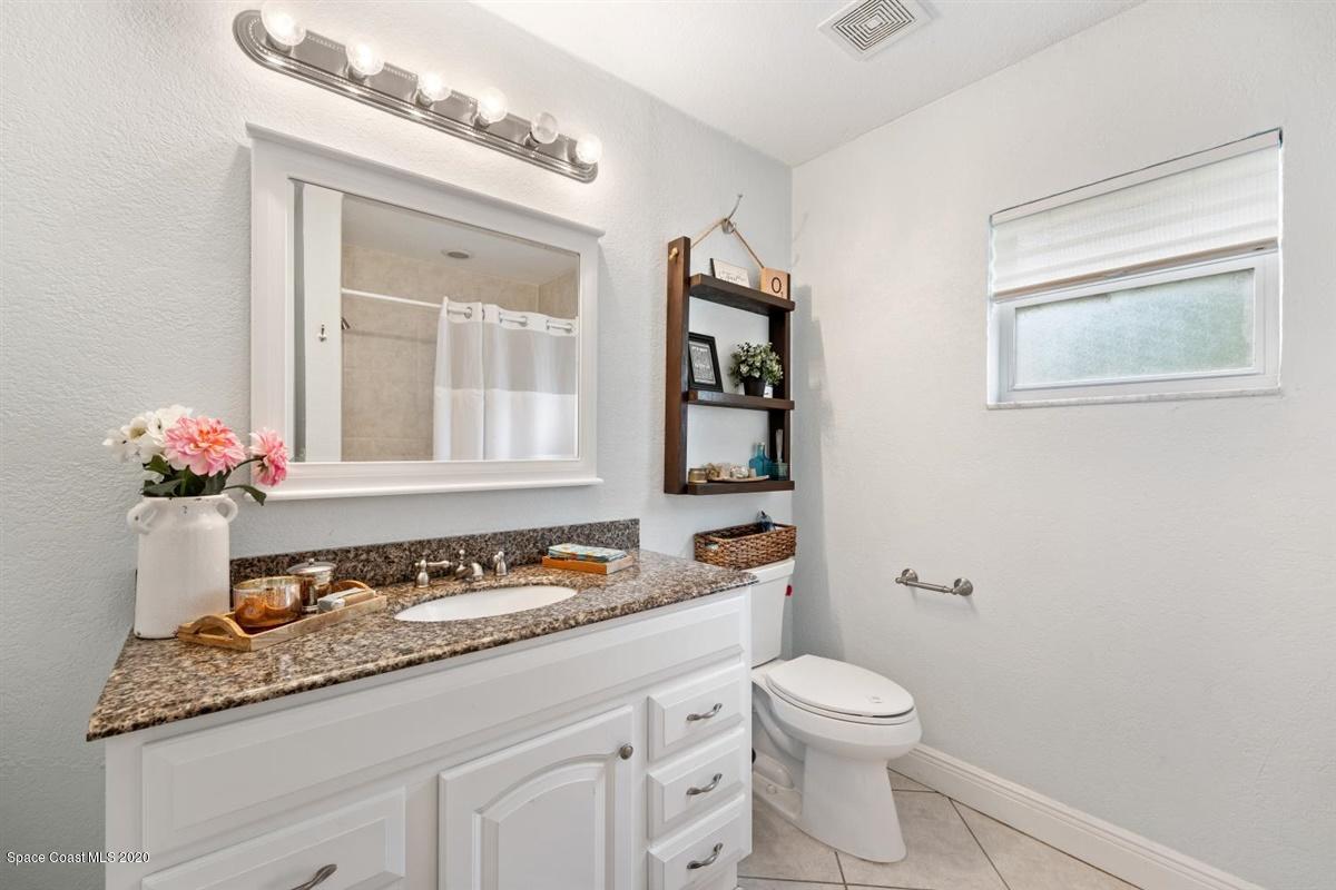 108 Neptune Court Indialantic, FL 32903 - Photo 29 of 33 a bathroom with a granite countertop sink mirror vanity and toilet