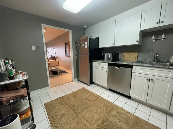 a kitchen with a sink window and stainless steel appliances