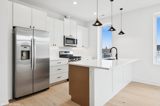 3219 North Elston Avenue, Unit 3 Chicago, IL 60618 - Photo 2 of 13 a kitchen with stainless steel appliances a refrigerator sink and microwave