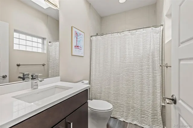 a bathroom with a granite countertop sink toilet and a mirror