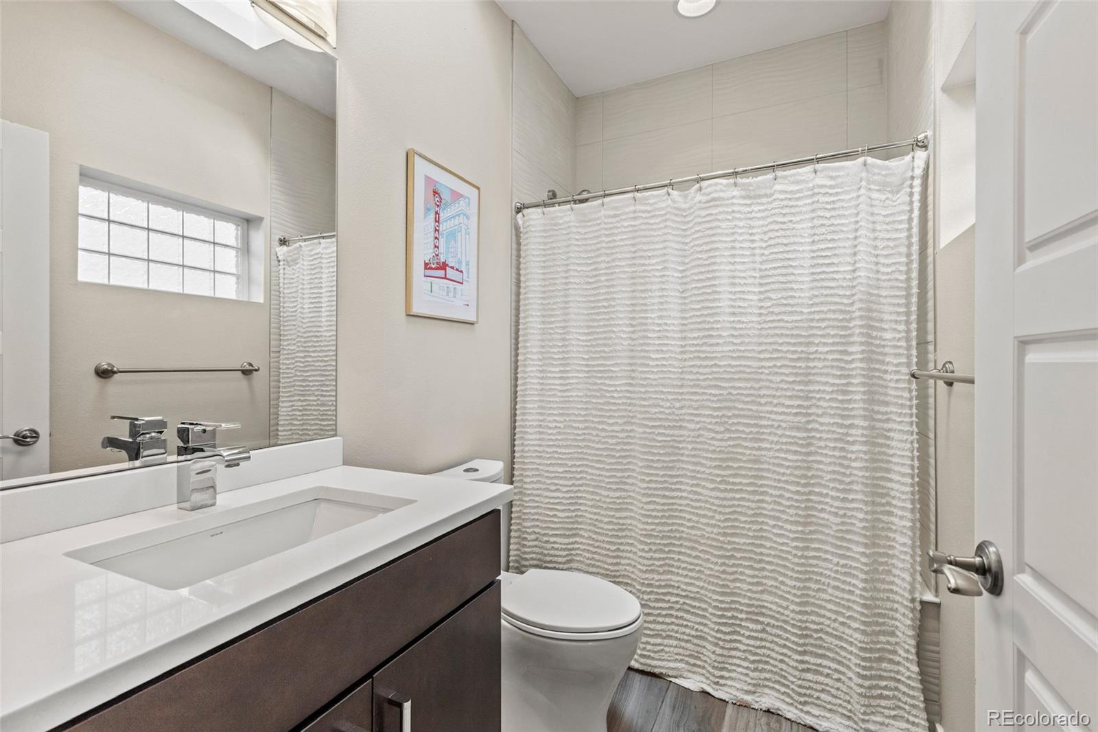3553 South Emerson Street, Unit 2 Englewood, CO 80113 - Photo 17 of 31 a bathroom with a granite countertop sink toilet and a mirror