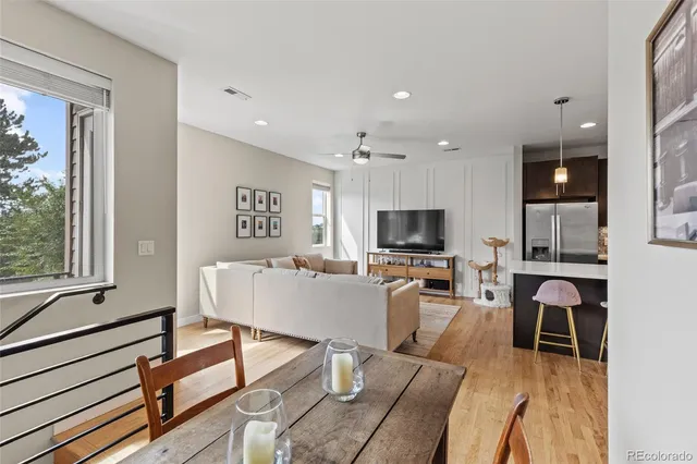 a living room with furniture a flat screen tv and a large window