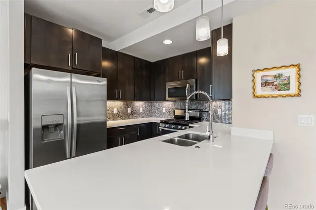 a kitchen with granite countertop a refrigerator stove and sink