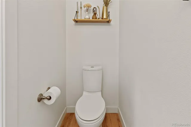 a white toilet sitting next to a white wall