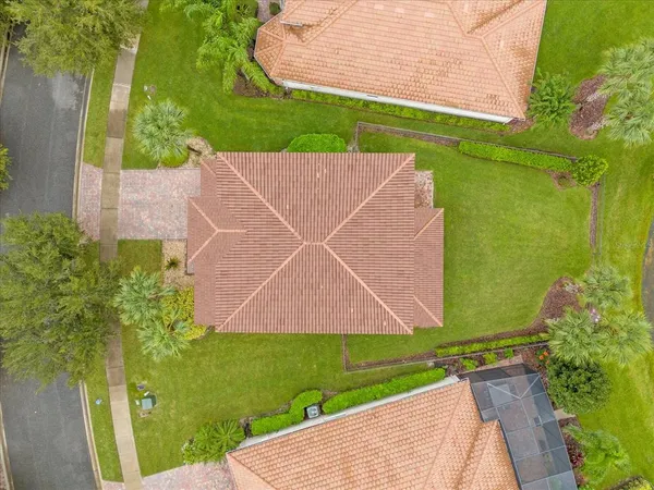 an aerial view of a house with a garden and lake view