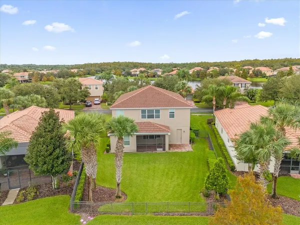 an aerial view of residential houses with outdoor space and lake view