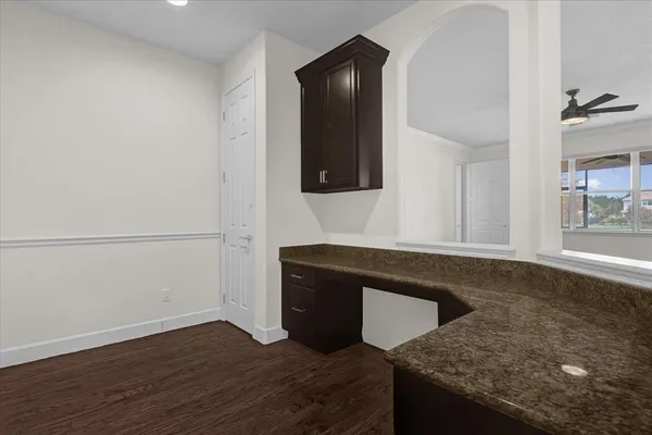 a view of a big room with wooden floor and a kitchen