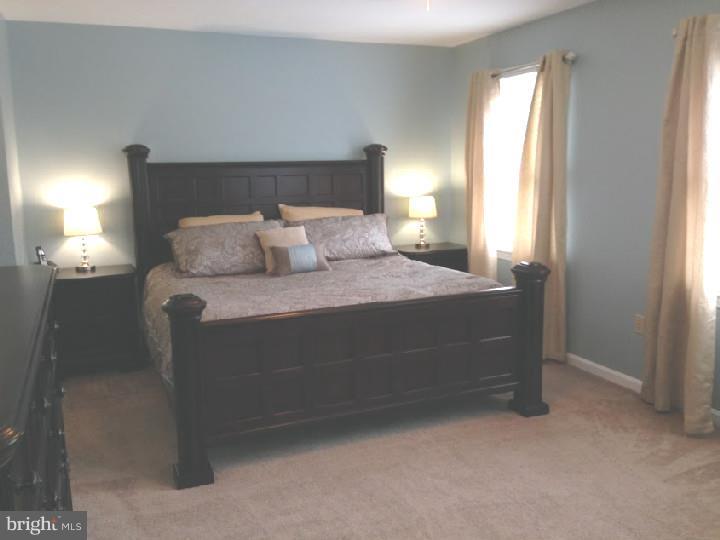 696 Guernsey Road South Landenberg, PA 19350 - Photo 15 of 25 a bedroom with a bed and a lamp