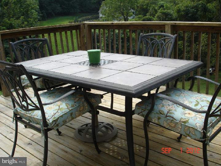 696 Guernsey Road South Landenberg, PA 19350 - Photo 4 of 25 a view of a wooden table and chairs on the roof deck