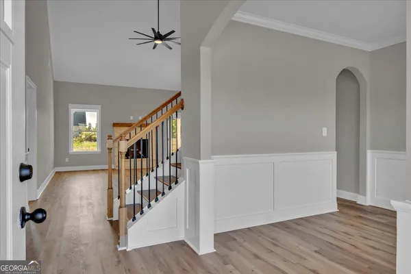 a view of a hallway with wooden floor and staircase