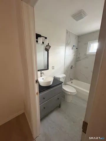 a bathroom with a toilet a sink and mirror