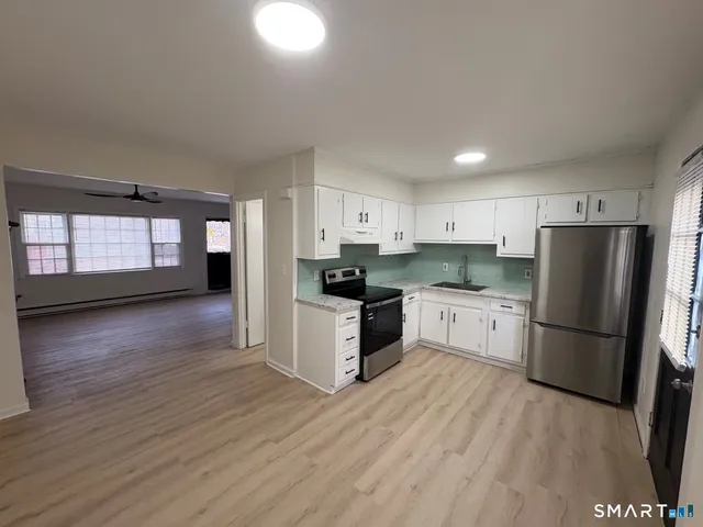 a kitchen with granite countertop a refrigerator and a stove top oven