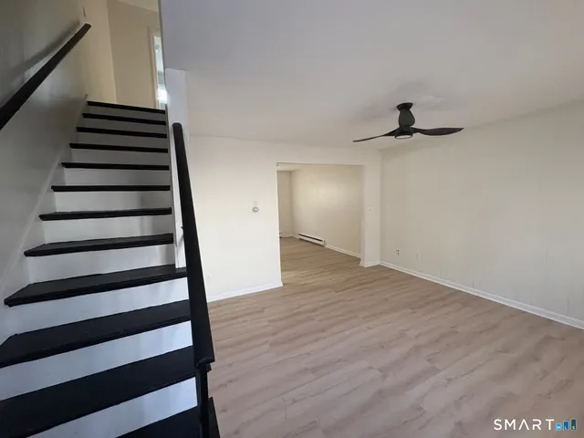a view of a hallway with wooden floor and entryway