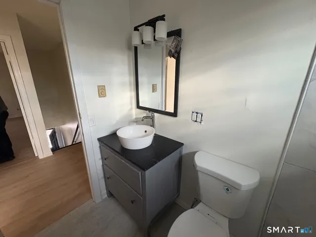a bathroom with a sink toilet and mirror