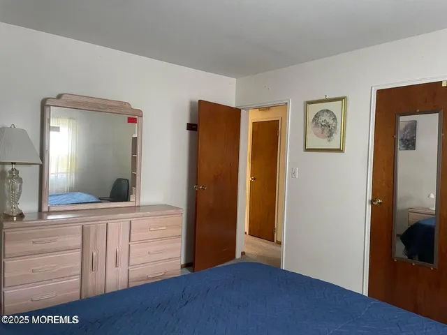 a view of a hallway with bathroom and mirror
