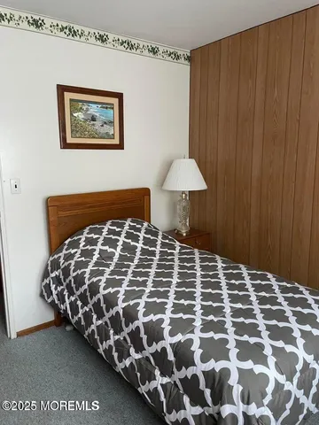 a large bed sitting in a bedroom next to a cabinet and a curtain