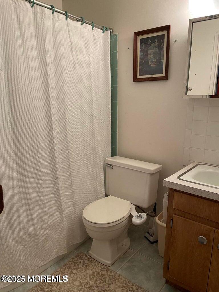 7 Walnut Street, Unit C Toms River, NJ 08757 - Photo 17 of 28 a white toilet sitting next to a shower curtain