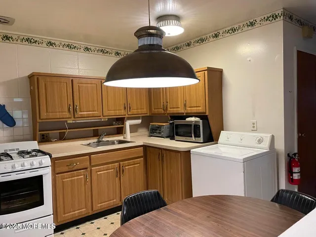 a kitchen with a sink a stove and cabinets