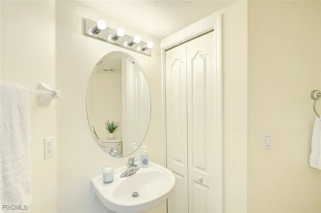 a bathroom with a sink a mirror a vanity and a shower