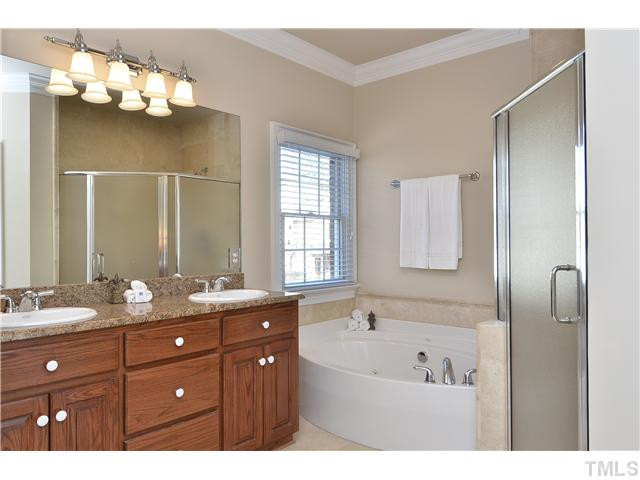 8311 Cazavini Court Raleigh, NC 27613 - Photo 14 of 22 a bathroom with a sink vanity tub and a mirror