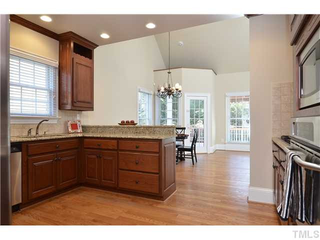 8311 Cazavini Court Raleigh, NC 27613 - Photo 5 of 22 a kitchen with granite countertop a sink cabinets and wooden floor