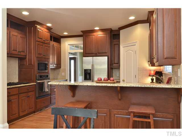 8311 Cazavini Court Raleigh, NC 27613 - Photo 6 of 22 a kitchen with kitchen island granite countertop a sink stainless steel appliances and cabinets
