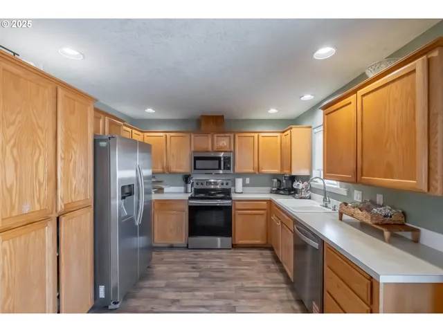 a kitchen with stainless steel appliances granite countertop a refrigerator a stove top oven a sink and dishwasher