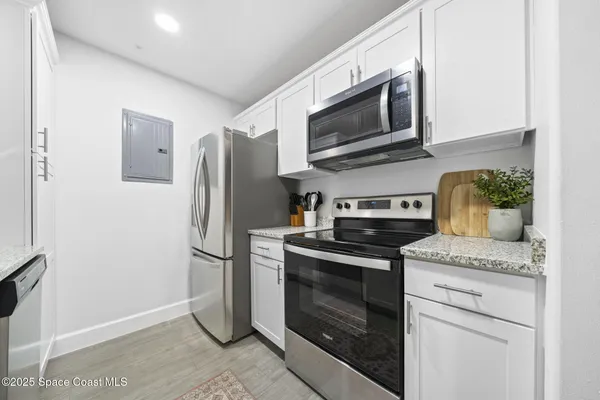 a kitchen with stainless steel appliances granite countertop a refrigerator and a stove
