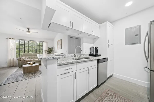 a living room with furniture and a dining table with kitchen view