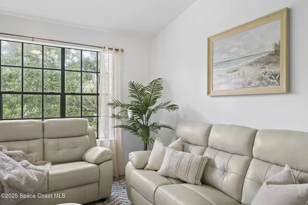 a living room with furniture and a floor to ceiling window