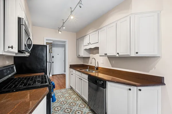 a kitchen with stainless steel appliances a sink stove and refrigerator