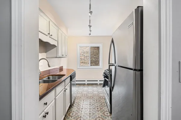 a kitchen with stainless steel appliances granite countertop a refrigerator and a stove