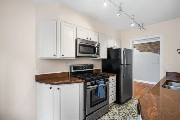 a kitchen with stainless steel appliances granite countertop a stove a refrigerator and a microwave