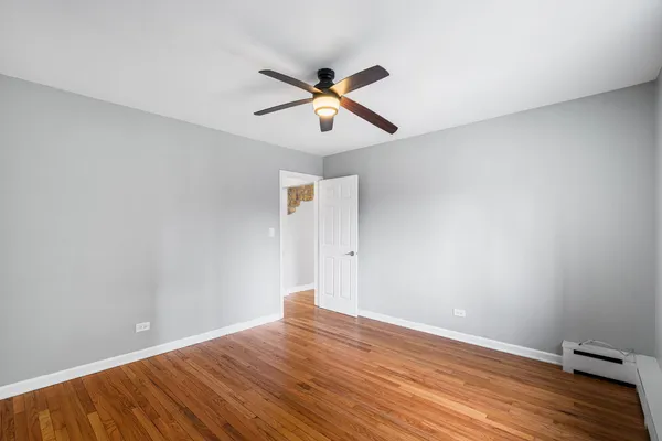 a view of a big room with wooden floor and windows