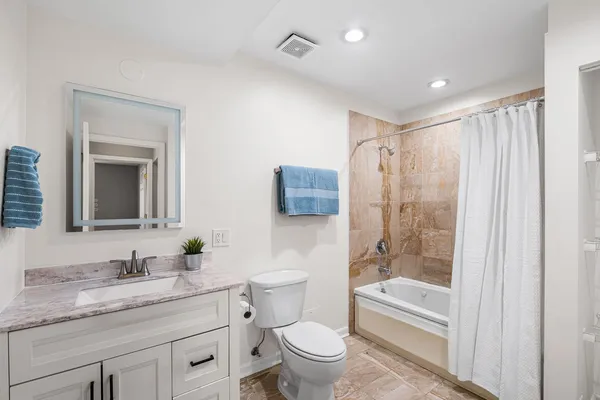 a bathroom with a granite countertop sink toilet and shower