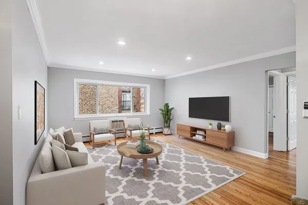 a living room with furniture a rug a flat screen tv and a window