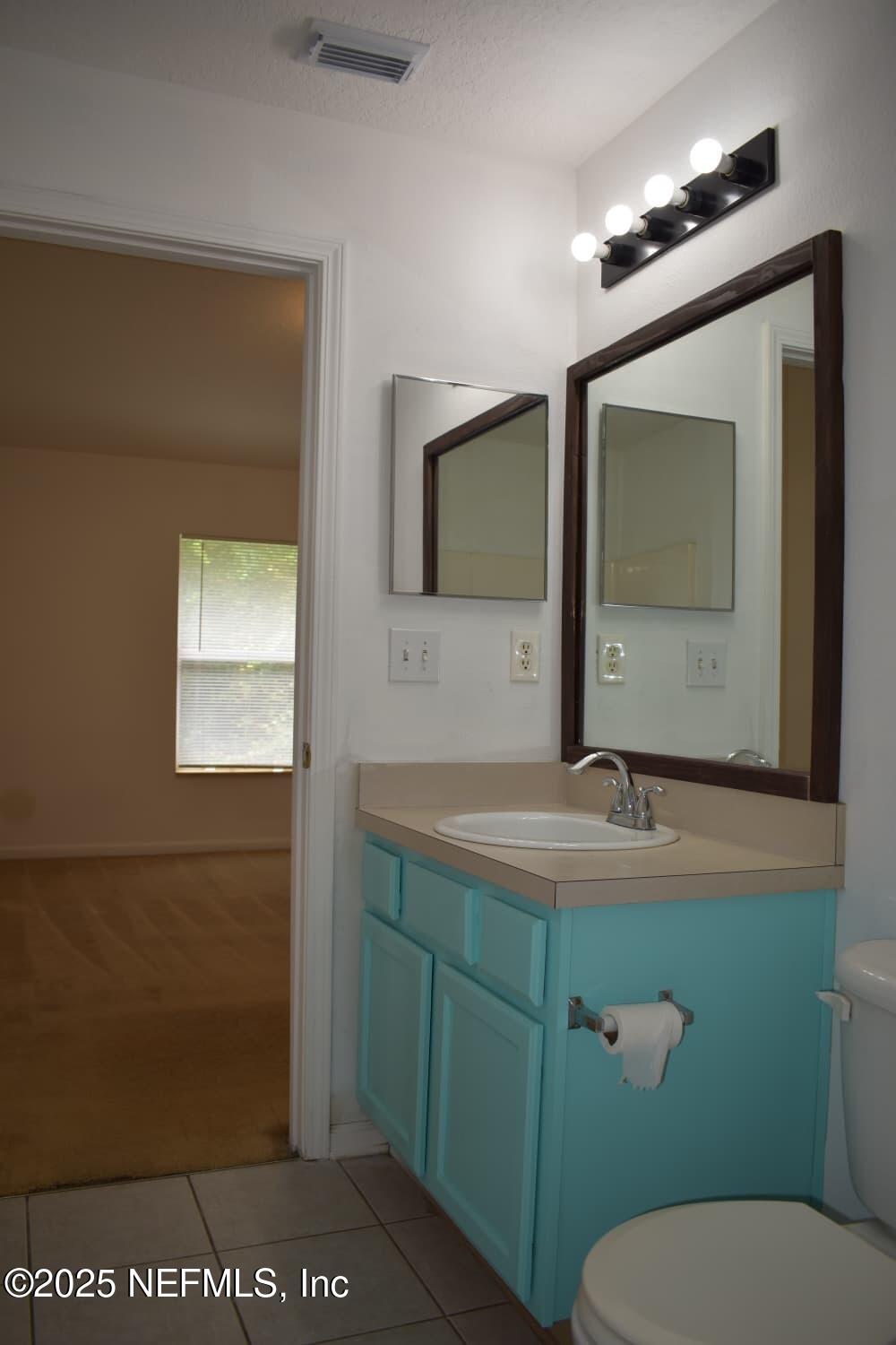 7920 Merrill Road, Unit 1710 Jacksonville, FL 32277 - Photo 22 of 51 a bathroom with a toilet sink and mirror