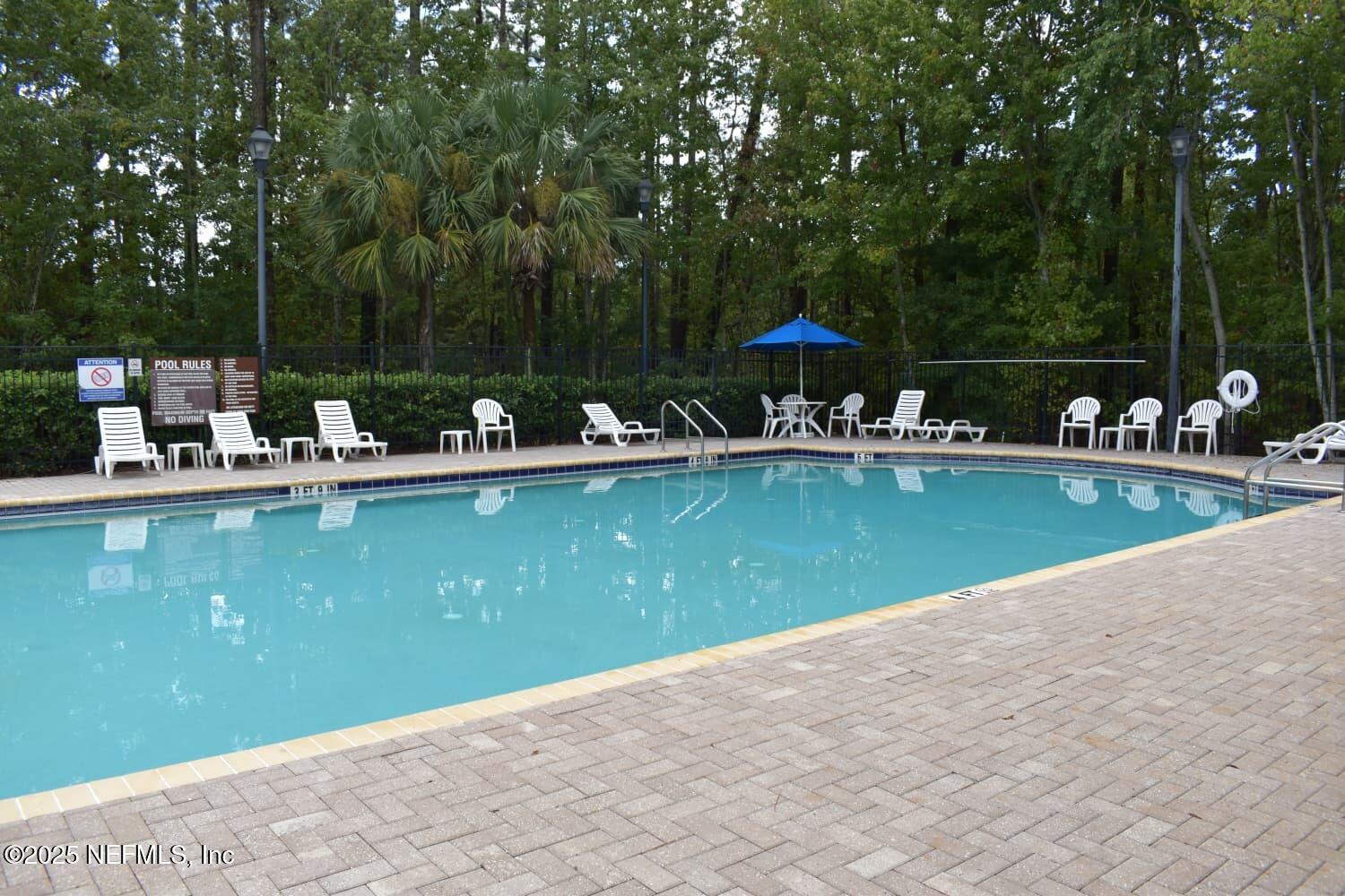7920 Merrill Road, Unit 1710 Jacksonville, FL 32277 - Photo 46 of 51 a view of a swimming pool with a bench and trees