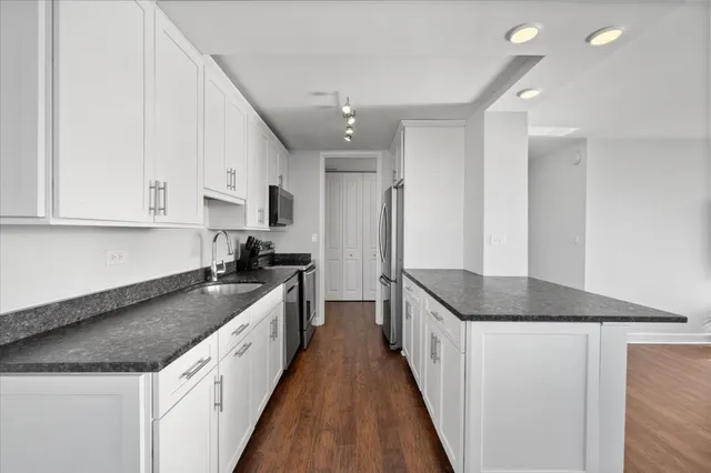 a kitchen with granite countertop a sink and cabinets