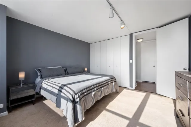 a spacious bedroom with a bed and a lamp