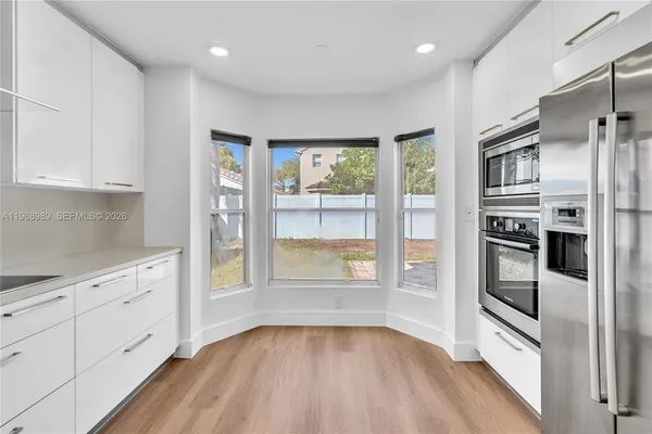 a kitchen with granite countertop stainless steel appliances a stove and a refrigerator