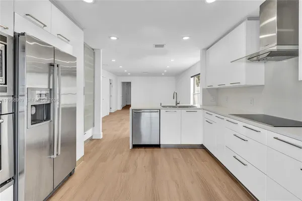 a kitchen with stainless steel appliances granite countertop a refrigerator and a stove top oven