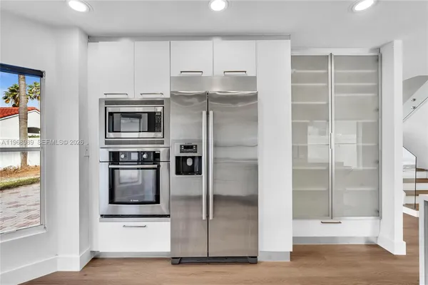 a kitchen with stainless steel appliances a refrigerator and a stove top oven