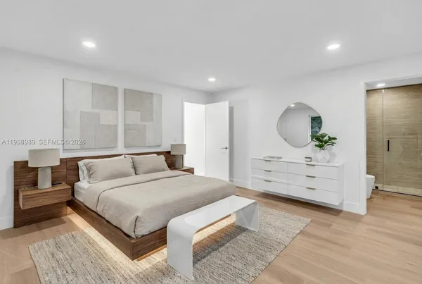 a spacious bedroom with a large bed and dresser