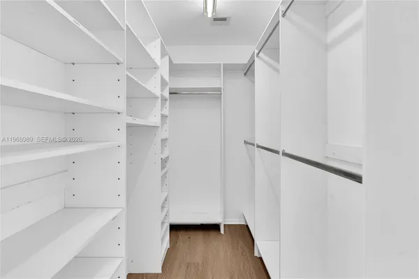 a view of walk in closet with wooden floor and window