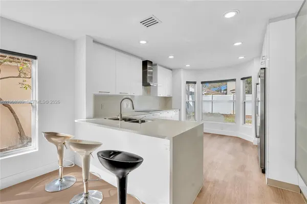 a kitchen with stainless steel appliances granite countertop a sink and a refrigerator