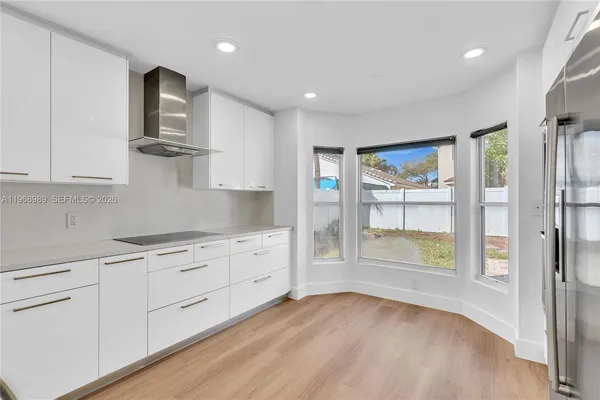 a kitchen with granite countertop white cabinets and stainless steel appliances