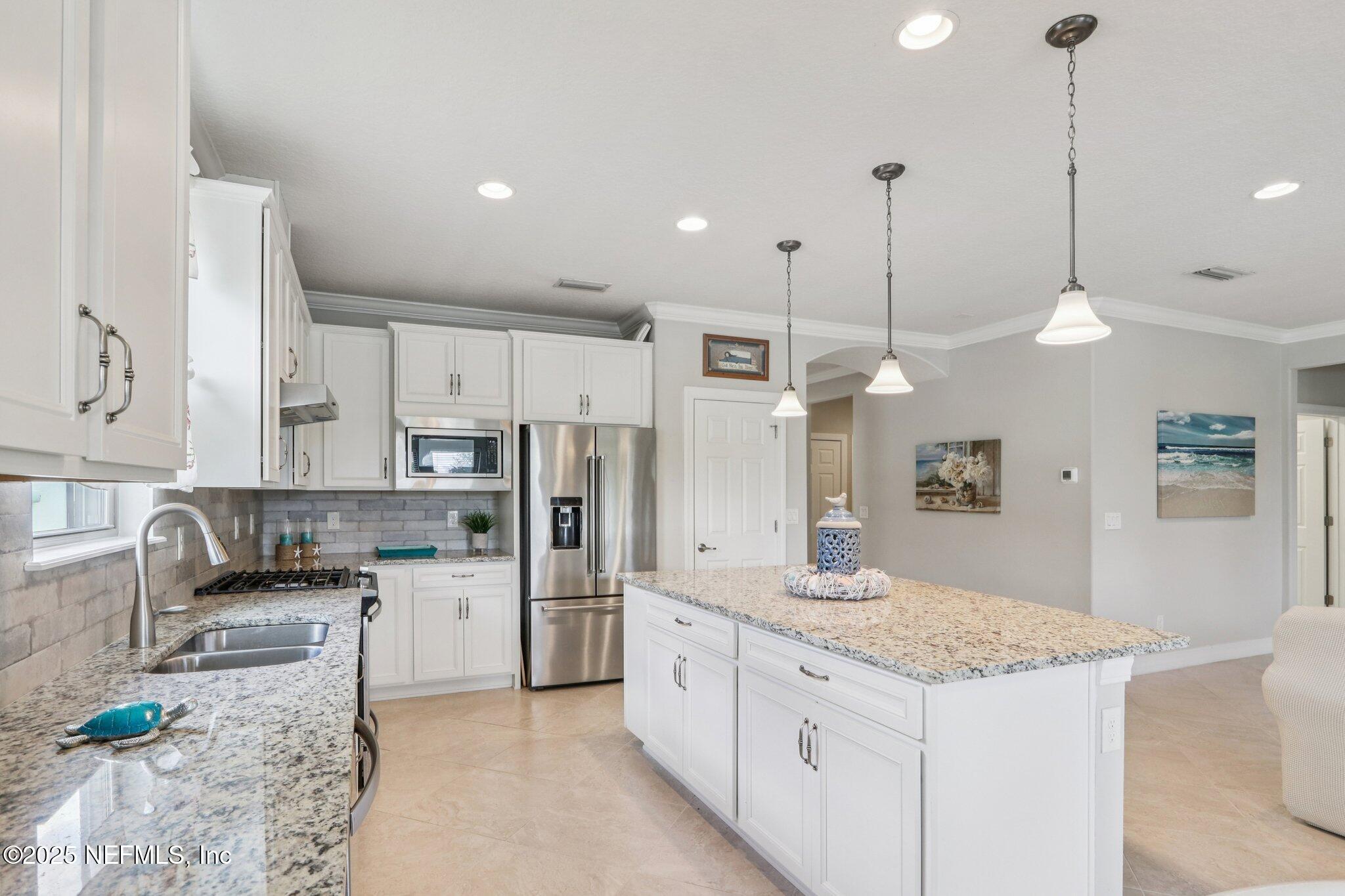 112 Bridge Oak Lane St. Augustine, FL 32095 - Photo 19 of 47 a kitchen with kitchen island granite countertop a sink a counter top space stainless steel appliances and cabinets