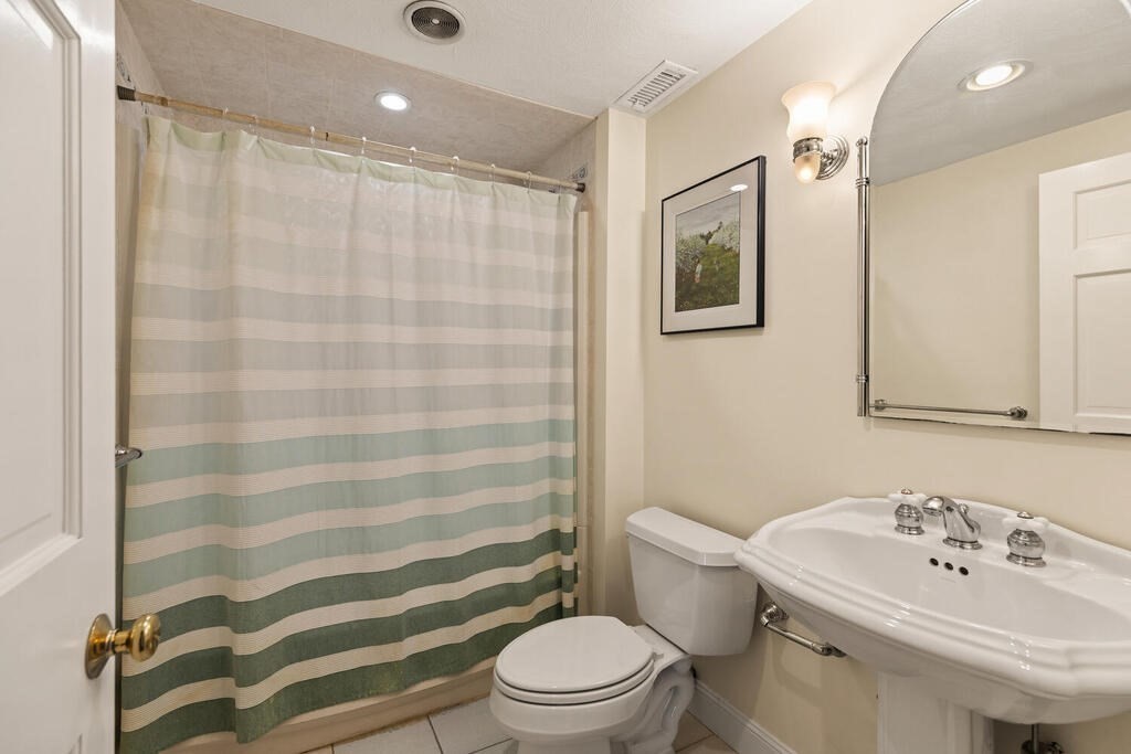 80 Bridge Street Lexington, MA 02421 - Photo 23 of 37 a bathroom with a sink a toilet a mirror and shower curtain